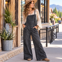 Woman wearing Charcoal Denim looking jumpsuit with a long sleeve lace top underneath