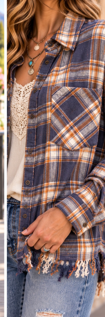 A close-up of a woman wearing a navy blue plaid button-up shirt with orange and beige stripes, layered over a white lace top and paired with distressed blue jeans.