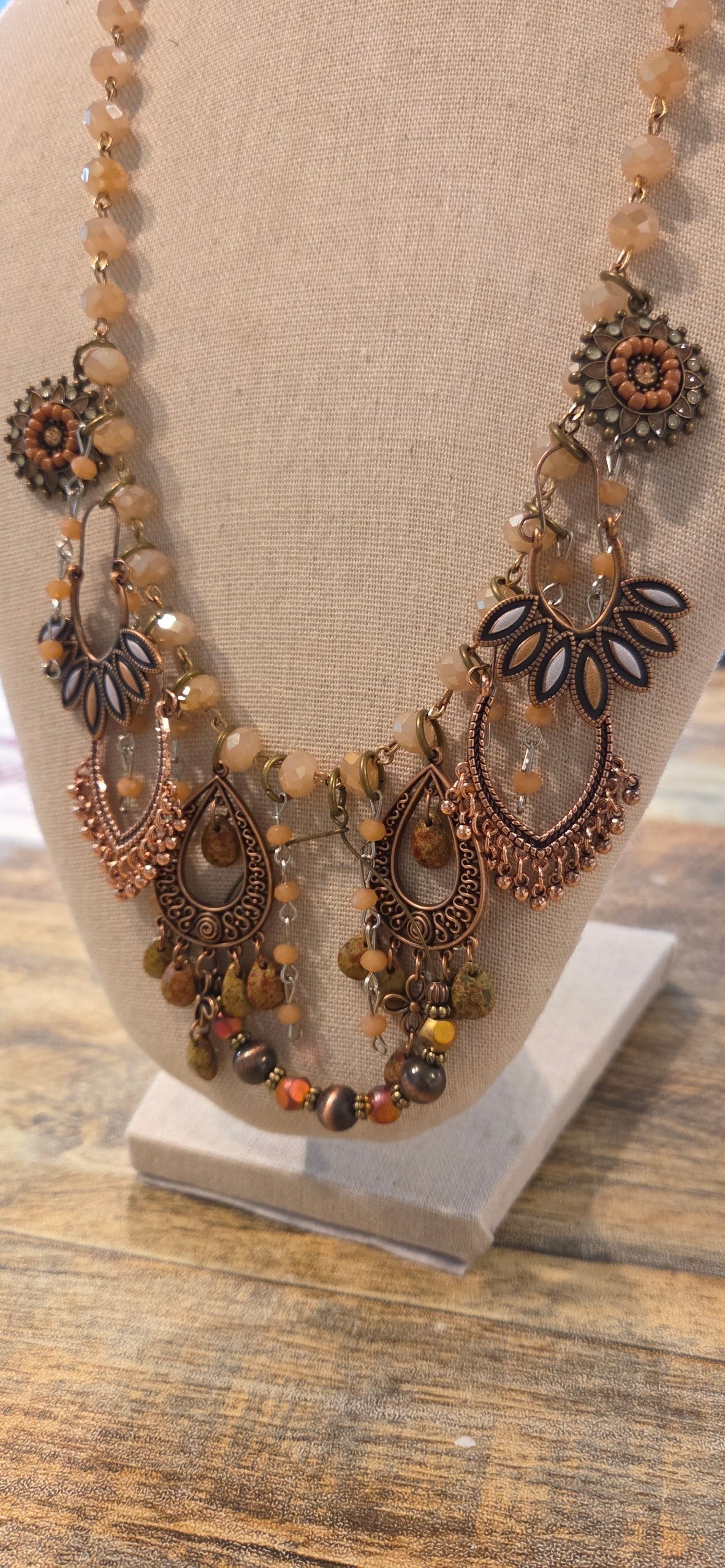 Handmade copper tone boho statement necklace with peach beads and layered fringe charms