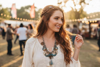 Woman wearing turquoise accent boho statement necklace with white embroidered top