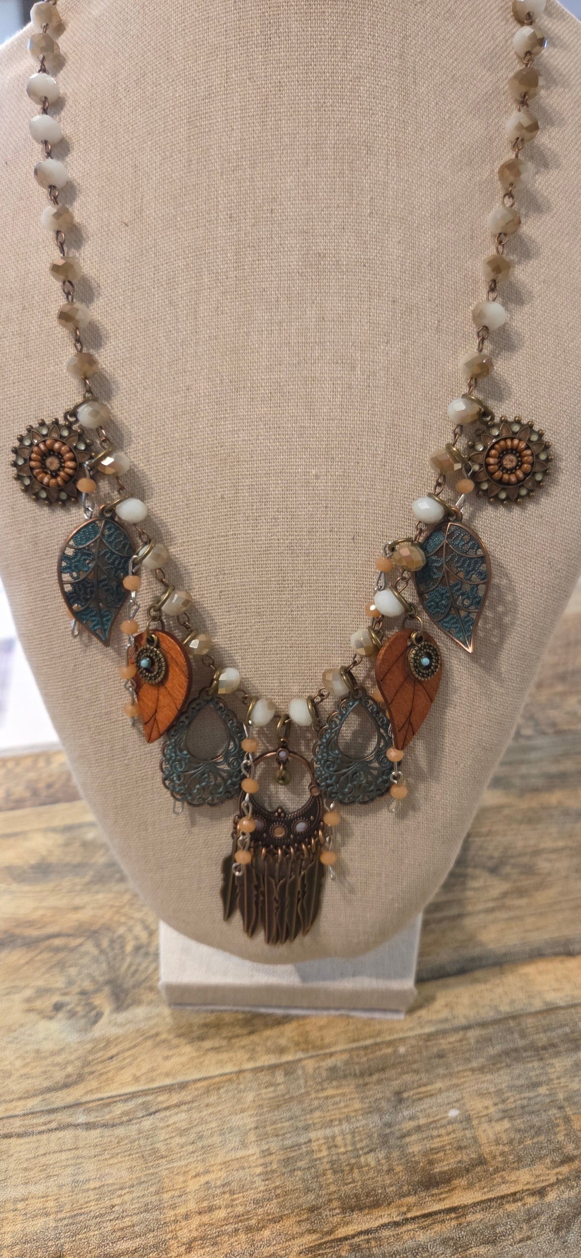 Handmade boho statement necklace with layered leaf charms and antiqued turquoise accents