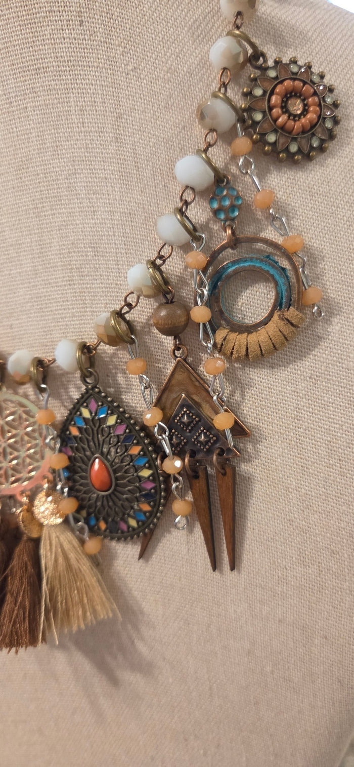 Close-up of handmade boho necklace with layered charms, beads and tassel details