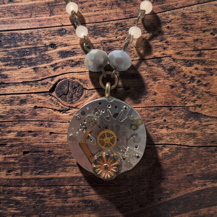 Close-up of Timekeeper necklace with intricate watch gears and floral detail