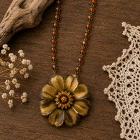 Gold flower boho statement necklace with amber beads styled on rustic wood