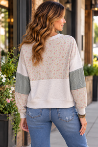 Back view of the NewIn pullover sweater with floral print and textured cable knit panels.