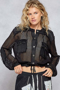 Woman wearing a black textured jacket with a gray background