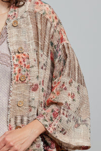 Textured jacket with floral patterns and buttons on a plain background