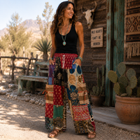 Lady wearing patched Palazzo Pants, paired with a simple black tank top, sandals, and some turquoise jewelry